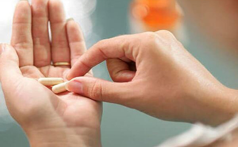 photo of woman taking pill